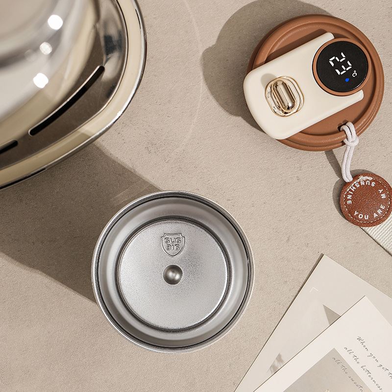 Flat lay of Embera's stainless steel inner chamber stamped SUS316, and its lid with digital display